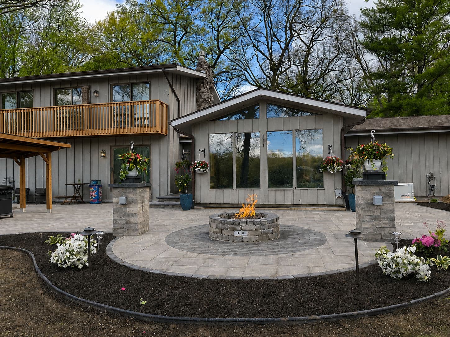 Modern backyard with a fire pit, patio, and lush landscaping near a contemporary home.